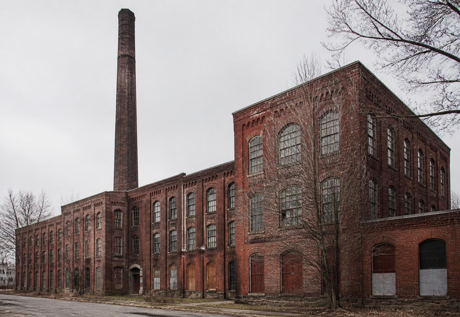 Historic brick textile mill building with tall arched windows in NoDa Charlotte